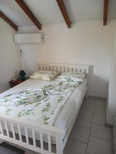 a bedroom with a white bed with a white bedspread at Source de vie - Campagne in Capesterre-Belle-Eau