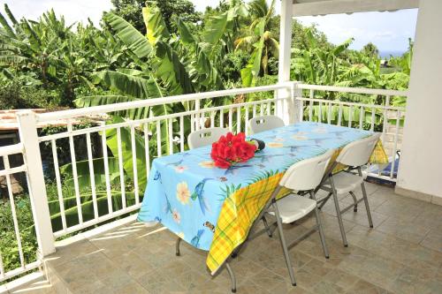 a table with a blue table cloth on a balcony at Source de vie - Campagne in Capesterre-Belle-Eau