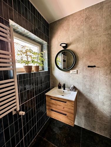 a bathroom with a sink and a mirror at Przystań Jeziorna in Pasym