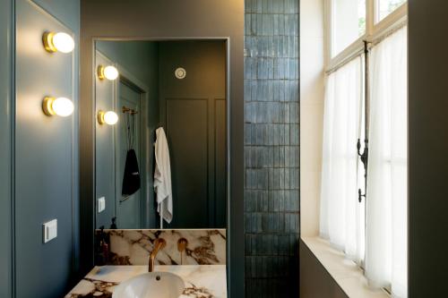 a bathroom with a sink and a mirror at Hotel Kasteel Doenrade in Doenrade