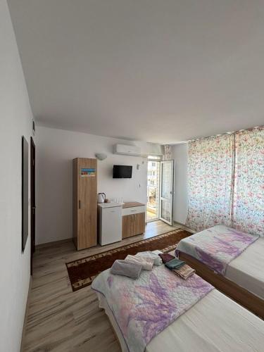 a white room with two beds and a bathroom at Къща за гости "Пердика" in Obzor