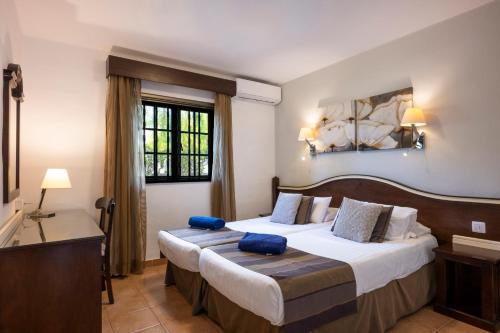 a hotel room with two beds and a window at Ona Las Casitas in Playa Blanca
