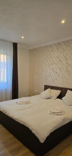 a bedroom with a large bed with white sheets at Casa Chișcău - Valea Urșilor in Chişcău