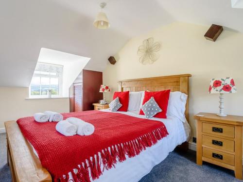 a bedroom with a red bed with towels on it at 1 Bed in Conwy oc-79357 in Llangelynin