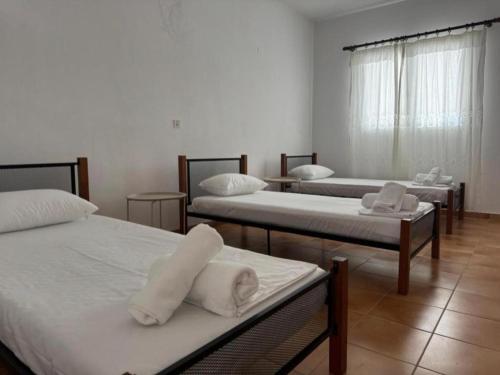 a room with three beds with white sheets at Kalloni Village House in Kalloní