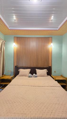a bedroom with a large bed with a wooden headboard at Bale Sunset Inn in Senaru