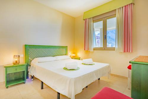 a bedroom with a large bed and a window at Apartamento Larimar - PlusHolidays in Ifach