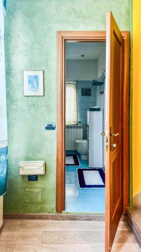 an open door to a bathroom with a refrigerator at Moon's House Oropa in Biella