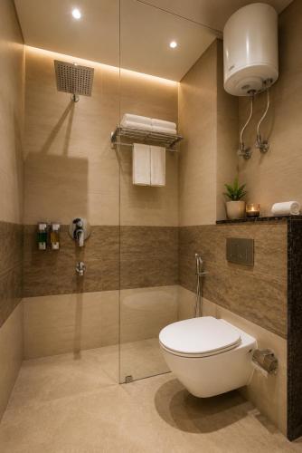 a bathroom with a toilet and a glass shower at Hotel Smart Premier -Delhi Airport in Behror