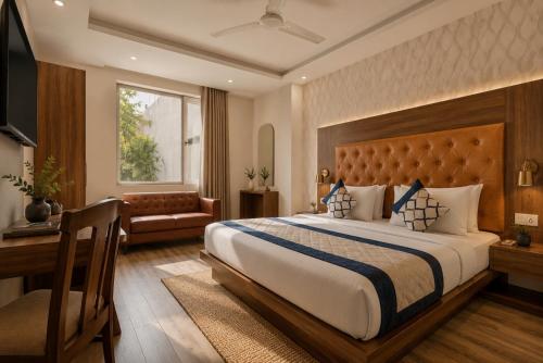 a hotel room with a large bed and a desk at Hotel Smart Premier -Delhi Airport in Behror