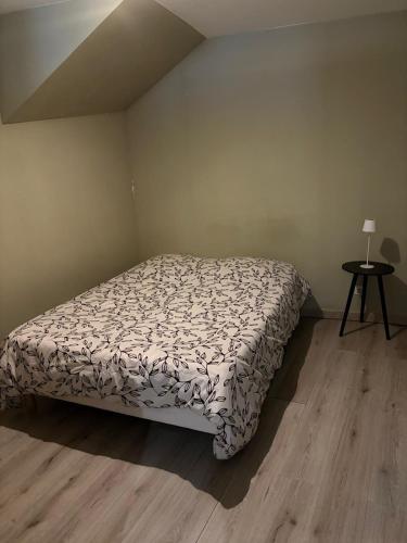a bedroom with a bed and a table with a lamp at T1 Meublé in Saint-Chamond