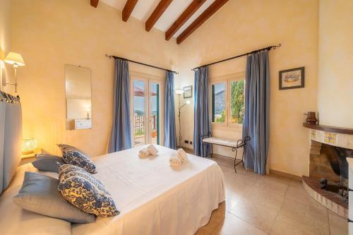 a bedroom with a large bed and a fireplace at Villa Calvario by Sealand Villas in Pollença