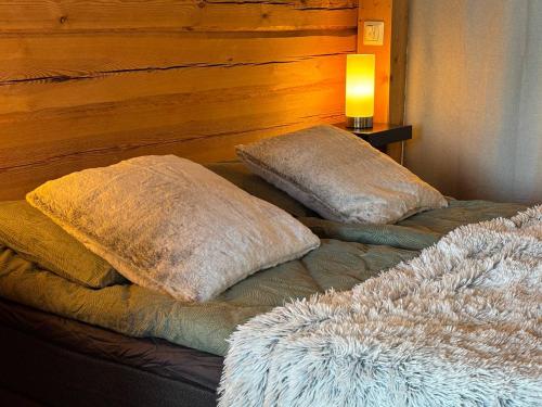 two pillows sitting on top of a bed with a lamp at Kyly in Savonlinna