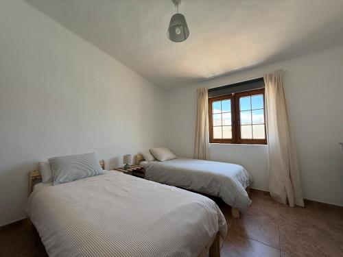 a bedroom with two beds and a window at Villa Ann Lanzarote in Nazaret