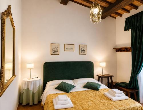 a bedroom with a large bed with a green headboard at Agriturismo Eco-Bio Villa Vacasio in Pitigliano