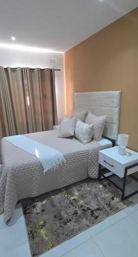 ein Schlafzimmer mit einem großen Bett und einem Tisch in der Unterkunft Asantha in Kalka