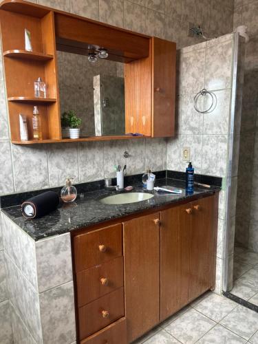 a bathroom counter with a sink and a mirror at Casa confort - Vicente pires in Brasília