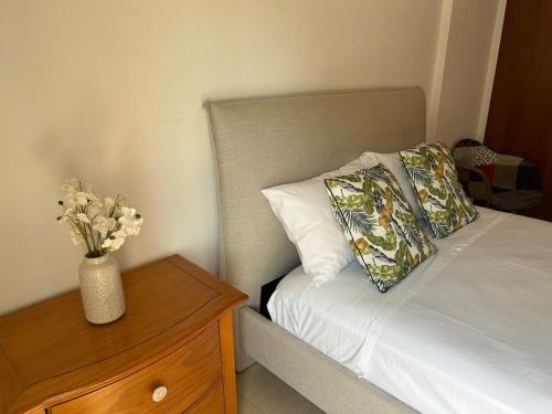 a bed with a vase of flowers on a night stand at Horizon Court in Kiti