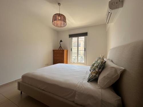 a bedroom with a bed and a window and a dresser at Horizon Court in Kiti