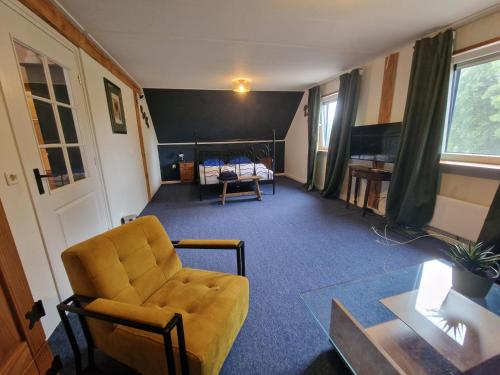 a living room with a couch and a bed at Vakantiewoning Blauhûs in Surhuisterveen