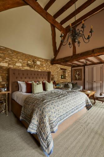 a bedroom with a large bed and a brick wall at The Porch House in Stow on the Wold