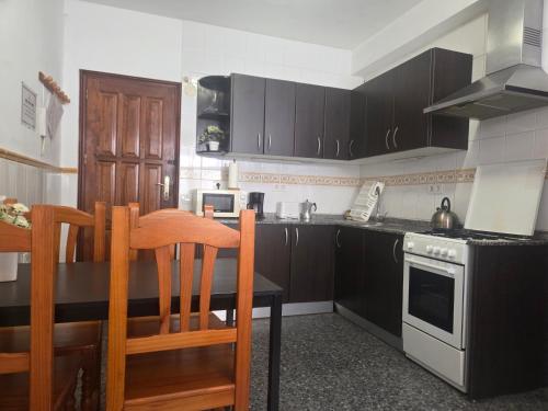 a kitchen with wooden cabinets and a table and a stove at Aguilon in Arrecife