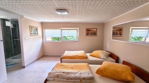 two beds in a room with two windows at Przytulne studio 