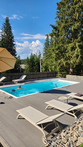 a swimming pool with chairs and people in it at Moho Будинки для відпочинку in Bukovel