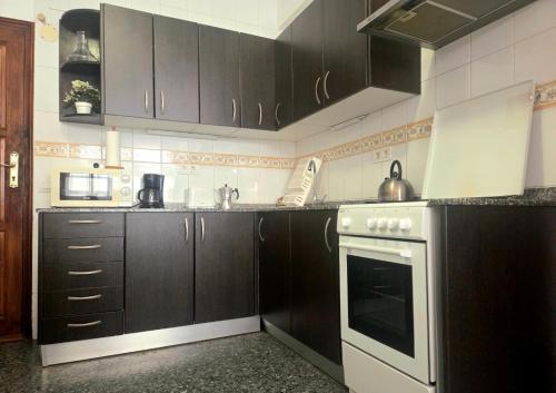 a kitchen with brown cabinets and a stove top oven at Aguilon in Arrecife