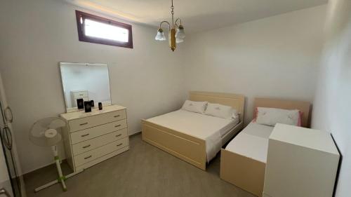 a bedroom with two beds and a dresser and a mirror at Vacation Home Hoxha in Rrotull