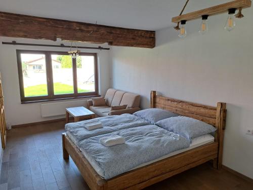 a bedroom with a large bed and a couch at Drevenica Šumiac in Šumiac