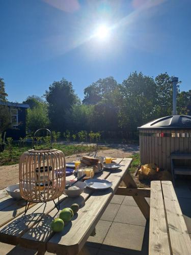 a picnic table with fruits and a bird cage on it at Cube 97 I 4 persoons chalet met hottub in Zennewijnen