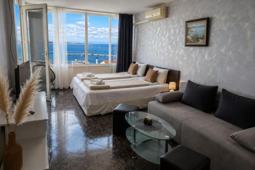 a hotel room with a bed and a couch at ORION Guest House in Sozopol