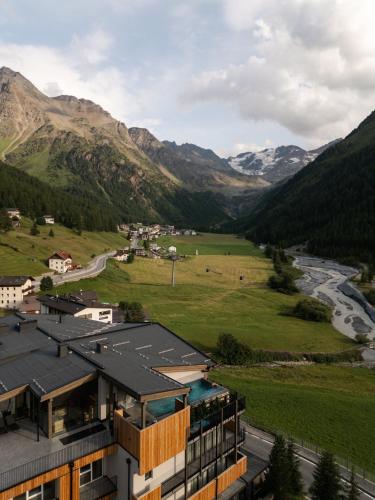 a building with a view of a river and mountains at MyPARADIES in Solda