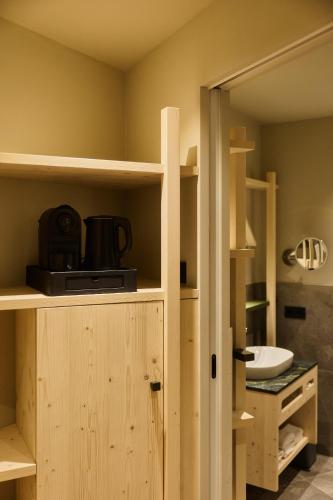 a kitchen with wooden shelves and a sink at Hotel AUI in Maranza