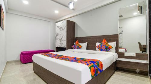 a bedroom with a large bed with a colorful blanket at homly hotel in Indore