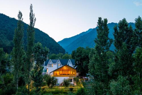a house in the mountains with its lights on at Moustache Pahalgam in Pahalgām