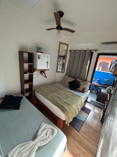 a bedroom with two beds and a ceiling fan at Suíte de Lane e Mú 2 in Abraão