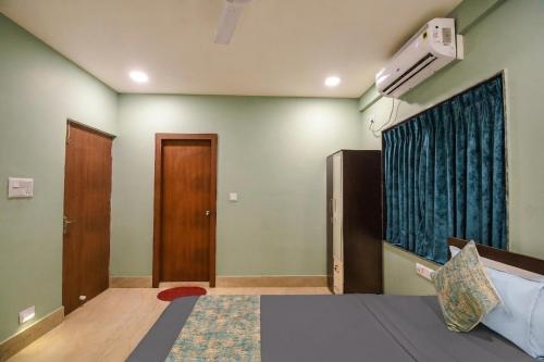a room with a bed and a window and a door at FabHotels Calyra in Karīmnagar