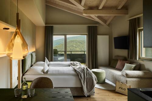 a living room with a bed and a large window at Hotel AUI in Maranza