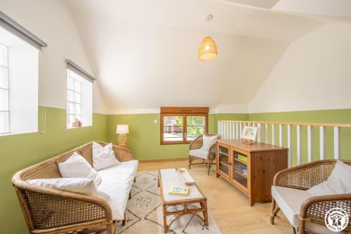 a living room with two chairs and a couch at Le clos bambou in Loueuse
