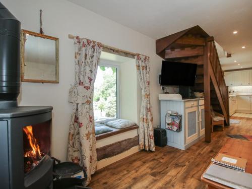 a living room with a fireplace and a window at Buzzards Breg in Builth Wells