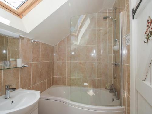 a bathroom with a tub and a sink at Buzzards Breg in Builth Wells