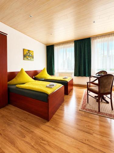 a bedroom with two beds and a table at Waldschloss Rathenow in Rathenow