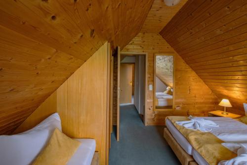a bedroom with two beds in a wooden cabin at Hotel garni Zwickau-Mosel in Mülsen