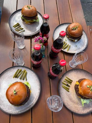 ein Tisch mit Tellern mit Essen und Flaschen mit Limonade in der Unterkunft Boutique-Stay in Eberswalde-Finow