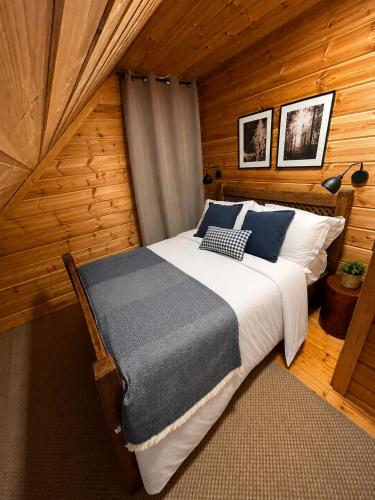 a bedroom with a bed in a wooden cabin at Chalet O Refúgio 3 in Penhas da Saúde
