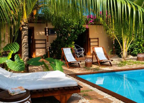 a resort with a pool and two chairs and a house at Ocean Breeze Boutique Hotel in Nungwi