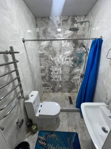 a bathroom with a toilet and a sink at Bella Hotel Navoi in Karmana