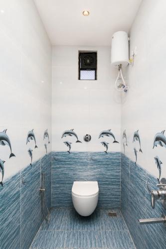 a bathroom with a toilet and dolphins on the wall at Hotel New Rajkamal in Aurangabad